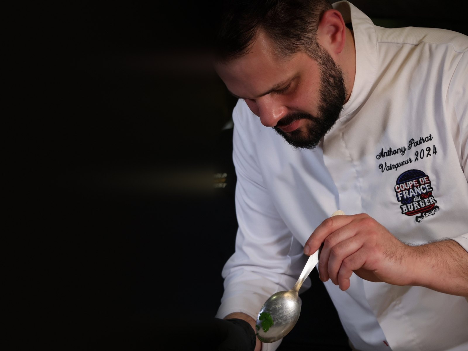 Anthony Pautrat, vainqueur de la Coupe de France du Burger 2024, en train de dresser un burger